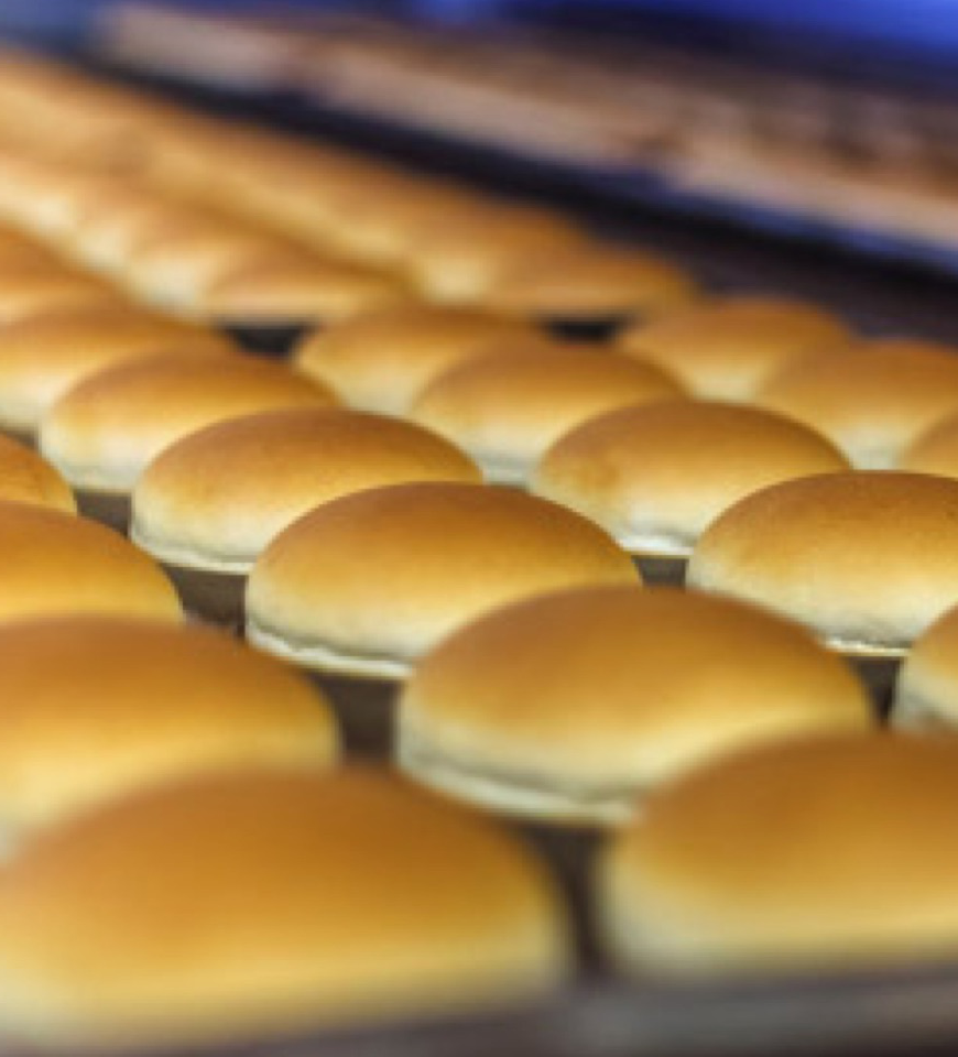东北食品公司将三明治面包放在烤盘上.